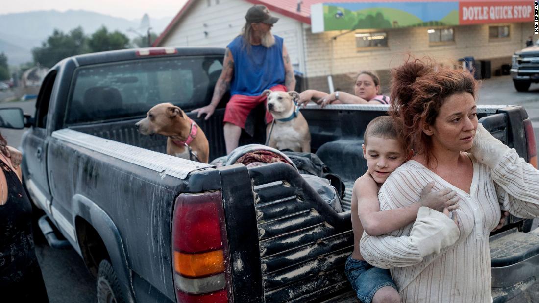 Destiney Barnard holds Raymond William Goetchius while stranded at a gas station in Doyle, Kalifornië, op Augustus 17. Barnard&#39;s car broke down as she was helping Raymond and his family flee the Dixie Fire.