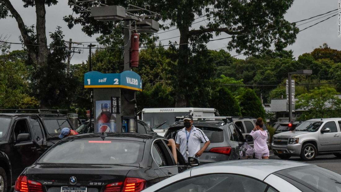 People line up to fuel their cars at a gas station on August 21 in Westhampton, 纽约.