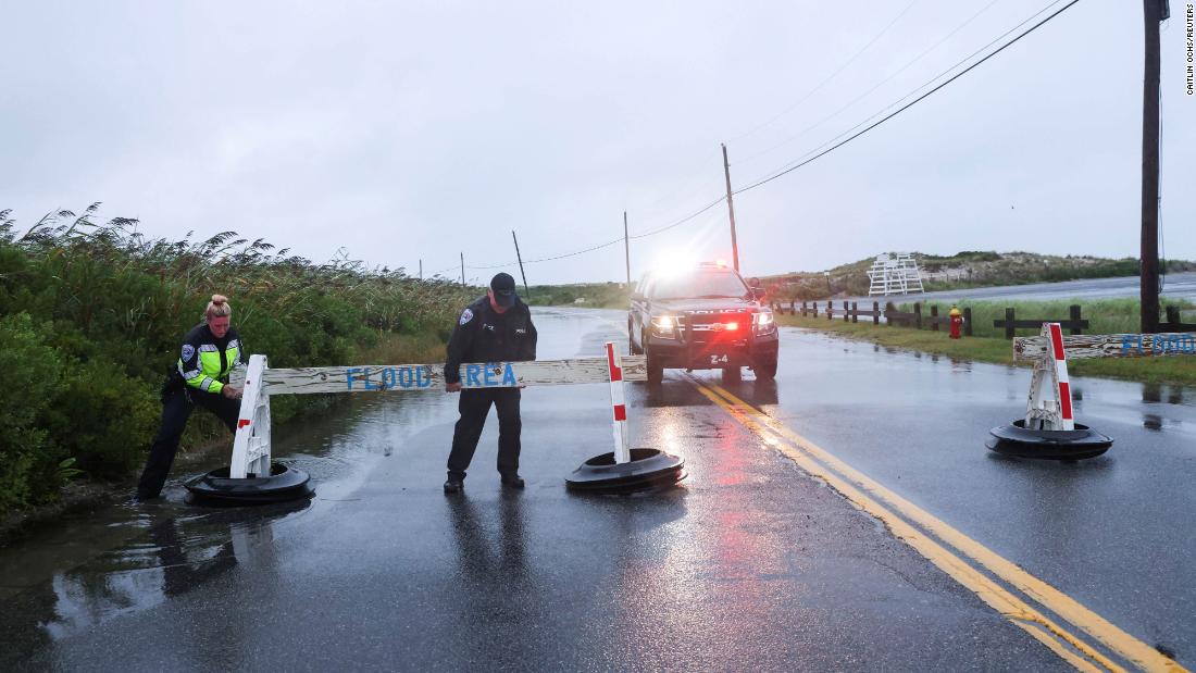 中士. Jim Cavanagh and officer Danielle McManus of the Southampton Town Police Department close a flooded road on Long Island, 纽约, 在八月 22.