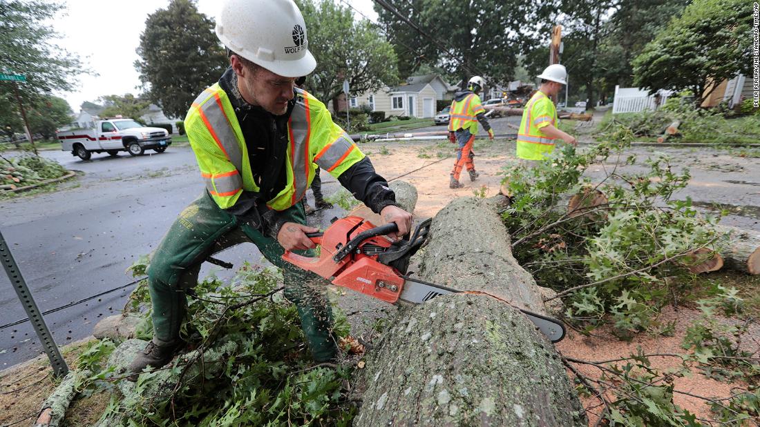 Ryan Bachus, who drove 17 hours from Tennessee with his colleagues from Wolf Tree to offer assistance, cuts down a tree that fell on Burns Street in New Bedford, 马萨诸塞州, because of high winds.