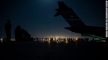 An air crew prepares to load evacuees aboard a C-17 Globemaster III aircraft at Hamid Karzai International Airport on August 21, 2021, 在喀布尔, 阿富汗. 