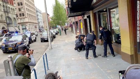 Police officers detain a man who opened fire with a handgun as a protest took place in downtown Portland on Sunday.
