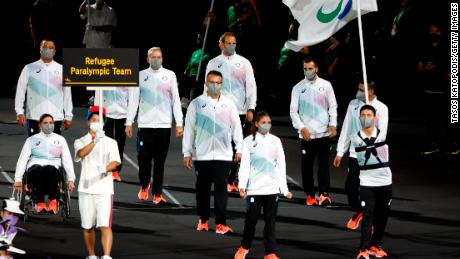 Karimi (正しい) led the Refugee Paralympic Team with fellow flagbearer Alia Issa (center left) in the parade of athletes during the Opening Ceremony of the Tokyo 2020 パラリンピック.