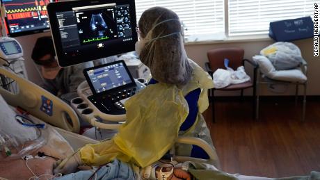 Tracy Brooks, an echocardiogram technician, takes readings from a critically ill Covid-19 patient, in an intensive care unit at the Willis-Knighton Medical Center in Shreveport, Louisiana.