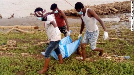 A body recovered from the Setit River bank by Wad El Hilou, Sudan, is carried on plastic sheeting.