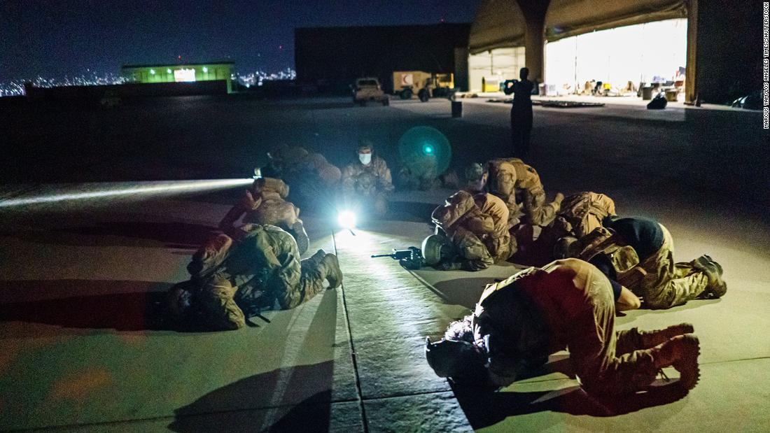 Taliban fighters bow in prayer on August 31 after they secured the Kabul airport and inspected the equipment that was left behind.