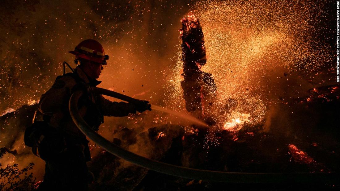 Jason Marone of the Roseville Fire Department hoses down a hot spot in Meyers, Kalifornië, op Augustus 31.