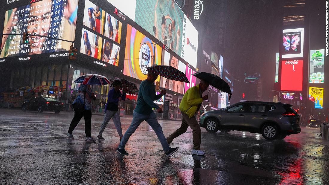 People walk through heavy rain in New York&#39;s Times Square on September 1.