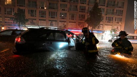 Members of the FDNY rescue a woman from her stalled car in New York.