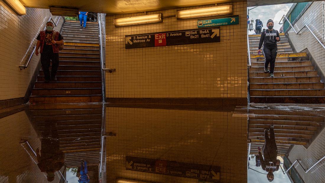 Commuters walk into a flooded subway station in New York City on September 2.
