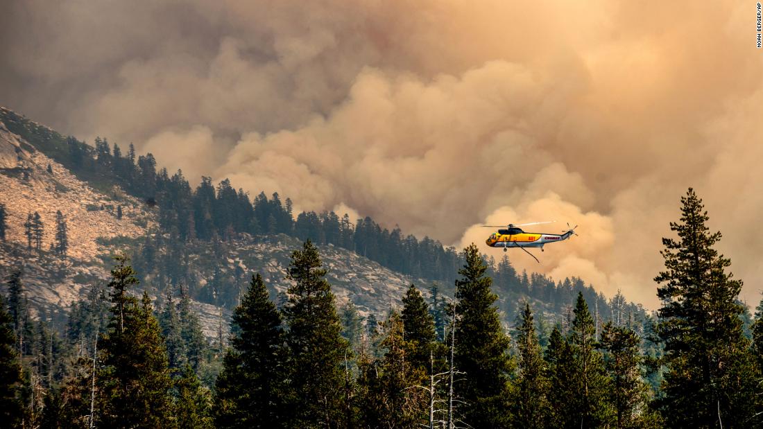 A helicopter flies over Wrights Lake while battling the Caldor Fire in California&#39;s Eldorado National Forest.