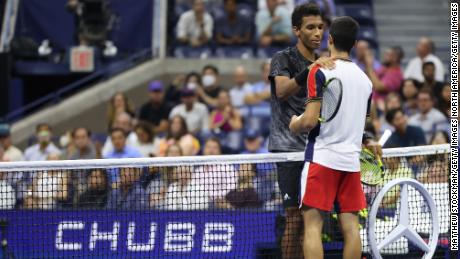 Felix Auger-Aliassime of Canada and Carlos Alcaraz of Spain meet at the net.