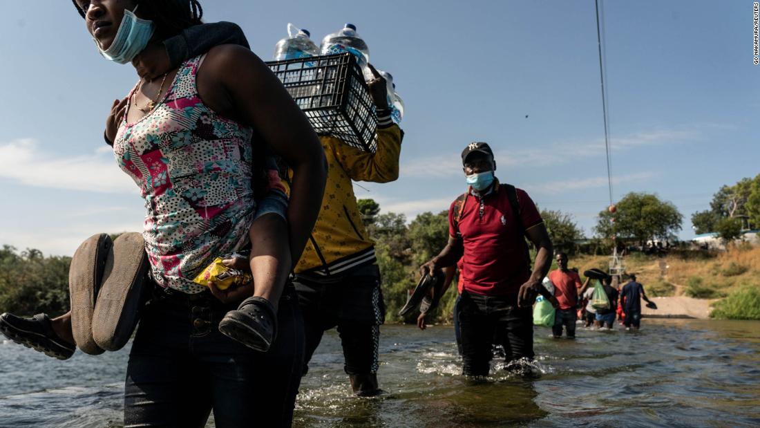Migrants wade in the Rio Grande near the International Bridge in Del Rio on September 16.