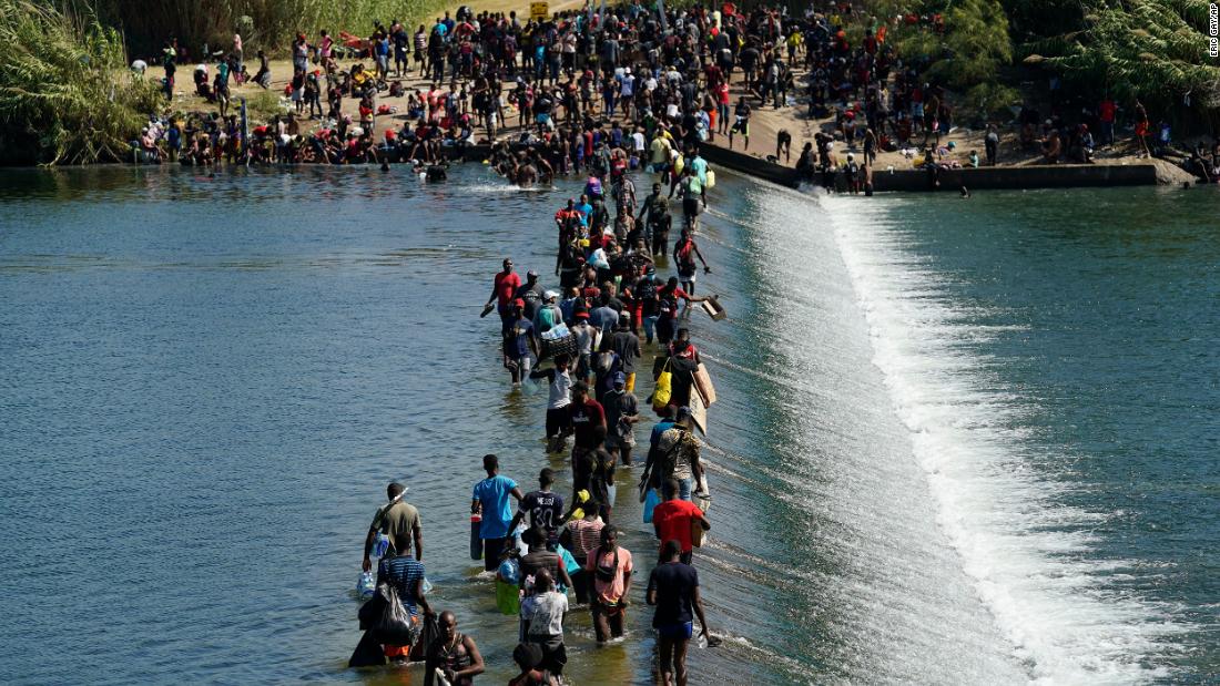 Migrants use a dam to cross to and from the United States from Mexico on Friday, septiembre 17. Thousands of migrants have assembled under and around a bridge in Del Rio, Texas, while awaiting processing by immigration agents.