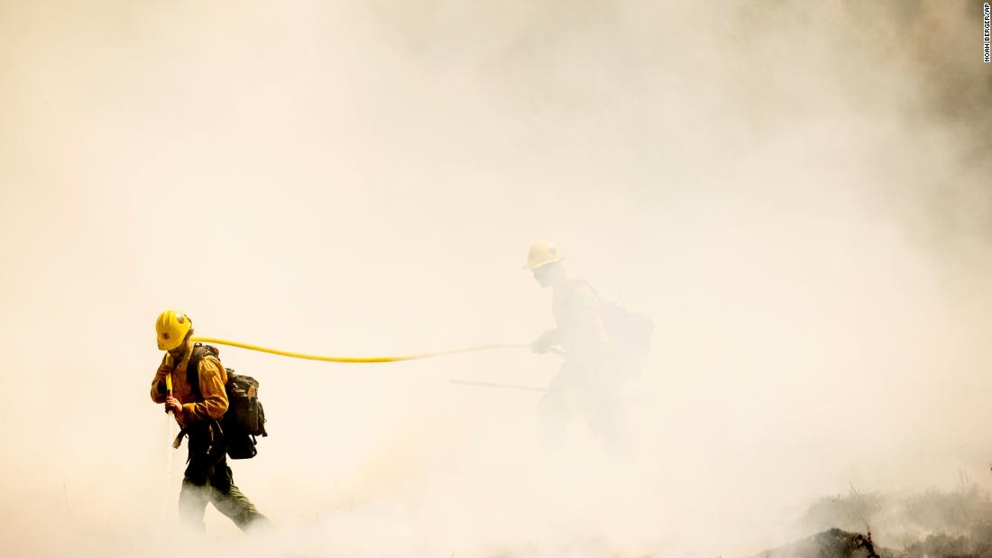 Firefighters battling the Windy Fire extinguish a spot fire near the Trail of 100 红杉国家森林中的巨人林, 加利福尼亚州, 在星期天, 九月 19.