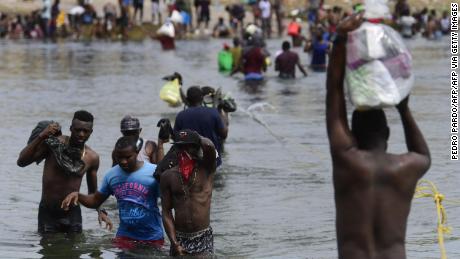 Haitian migrants cross the Rio Grande river to get food and water in Mexico, as seen from Ciudad Acuna, Coahuila state, Mexico on September 21, 2021. - Mexico has told the United States that it wants a regional agreement to tackle the tide of migrants arriving at the two countries&#39; borders, Foreign Minister Marcelo Ebrard said Tuesday. (Photo by PEDRO PARDO / AFP) (Photo by PEDRO PARDO/AFP via Getty Images)