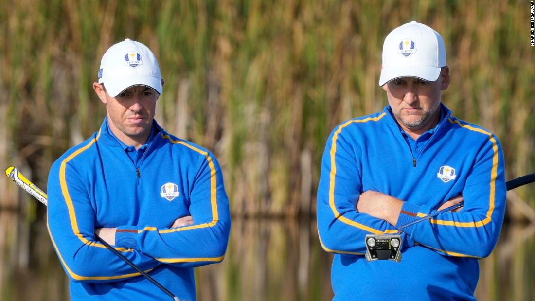 Team Europe&#39;s Rory McIlroy and Ian Poulter wait to putt on the fifth hole.