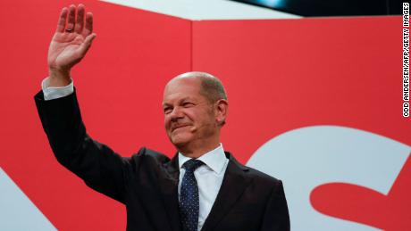 Olaf Scholz waves at SPD headquarters after the estimates were broadcast on TV, in Berlin.