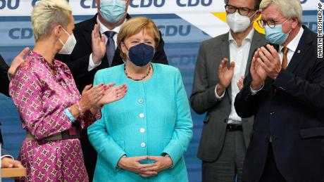 La canciller alemana, Angela Merkel, se alza mientras los principales miembros de la CDU aplauden el domingo.