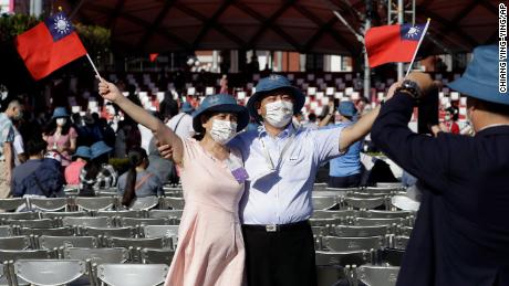 A couple take a photo with Taiwan national flags during National Day celebrations in front of the Presidential Building in Taipei, Taiwan.