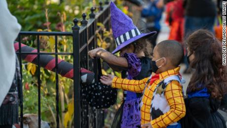 Children receive treats by candy chutes while trick-or-treating for Halloween in Woodlawn Heights on October 31, 2020 in New York City. 
