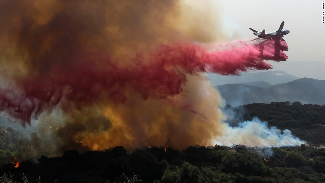Un avión cisterna cae retardante en un incendio forestal en Goleta. 