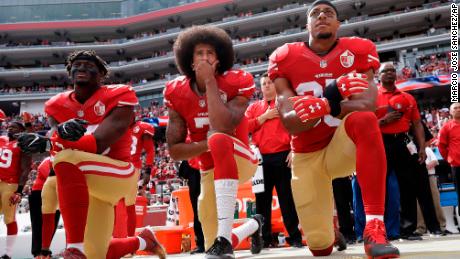 San Francisco 49ers Eli Harold, left, Colin Kaepernick, center, and Eric Reid kneel during the national anthem before the team&#39;s game against the Dallas Cowboys.