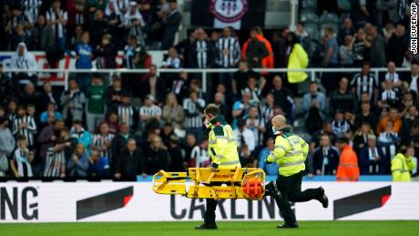 Medics run with a stretcher to treat someone in the crowd during the game between Newcastle and Tottenham Hotspur.