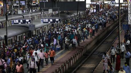 مسافر 30 ستمبر 2021 کو ممبئی کے چھترپتی شیواجی مہاراج ٹرمنس پر چوٹی کے اوقات کے دوران لوکل ٹرینوں کا انتظار کرتے ہیں۔ 