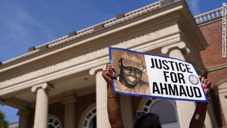 A demonstrator holds a sign at the Glynn County Courthouse as jury selection begins in the trial of Arbery&#39;s shooting death on October 18, 2021 in Brunswick, Georgia.