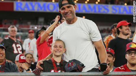 Cancer survivor Noah Reeb and his father smile after Brady handed him a hat.