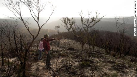 Two people walk through a fire-ravaged area in the the Greater Blue Mountains World Heritage Area near the town of Blackheath, Australia, on February 21, 2020.