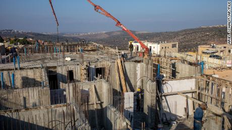 فلسطینی مزدور پیر 25 اکتوبر 2021 کو مغربی کنارے کی یہودی بستی بروچن میں نئے گھر بنا رہے ہیں۔ 
