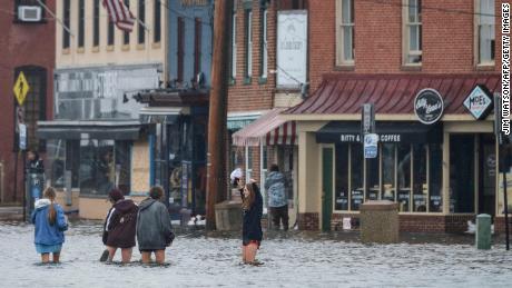 A group of people wade through flood waters in downtown Annapolis, Maryland, on October 29, 2021.