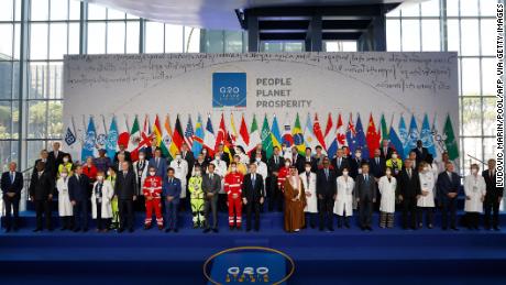 اطالوی وزیر اعظم ماریو ڈریگی، سینٹر فرنٹ، اطالوی میڈیکل ٹیم اور عالمی رہنماؤں کے ساتھ کھڑے ہیں جب وہ ہفتہ، اکتوبر 30، 2021 کو روم میں لا نیوولا کے کنونشن سینٹر میں G20 سربراہی اجلاس کے پہلے دن سرکاری خاندانی تصویر کے لیے جمع ہو رہے ہیں۔ .