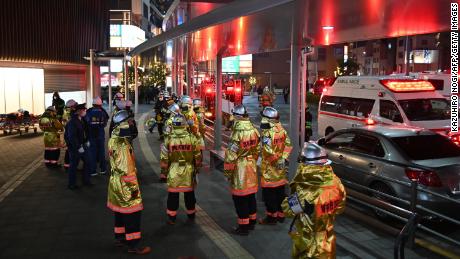 Firefighters gather outside Kokuryo Station on the Keio Line in the city of Chofu in western Tokyo on October 31, 2021.