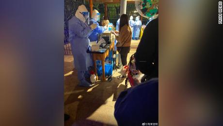 Shanghai Disneyland visitors queue for Covid-19 testing after the park announced a snap lockdown on Sunday.