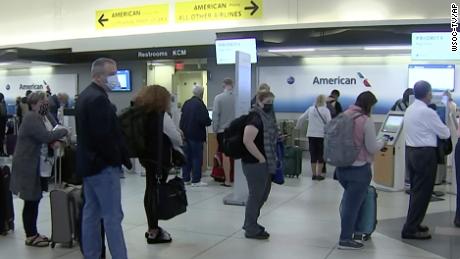 لوگ اتوار کو شارلٹ کے ایک ہوائی اڈے پر امریکن ایئر لائن کے کاؤنٹر پر قطار میں کھڑے ہیں۔  ایئر لائن نے اتوار کو 800 سے زیادہ پروازیں منسوخ کر دی ہیں، یا اس دن کے شیڈول کا تقریباً 20 فیصد۔