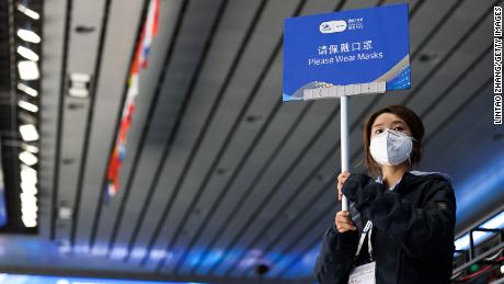 بیجنگ، چین میں 21 اکتوبر کو بیجنگ 2022 کے سرمائی اولمپکس کے ٹیسٹ ایونٹ کے دوران ایک رضاکار ایک نشان اٹھائے ہوئے ہے۔