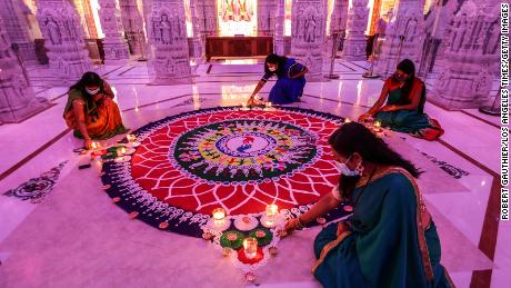 Women tend to a rangoli, a geometric pattern typically created using colored sand, during a Diwali celebration in Chino Hills, California, in 2020.