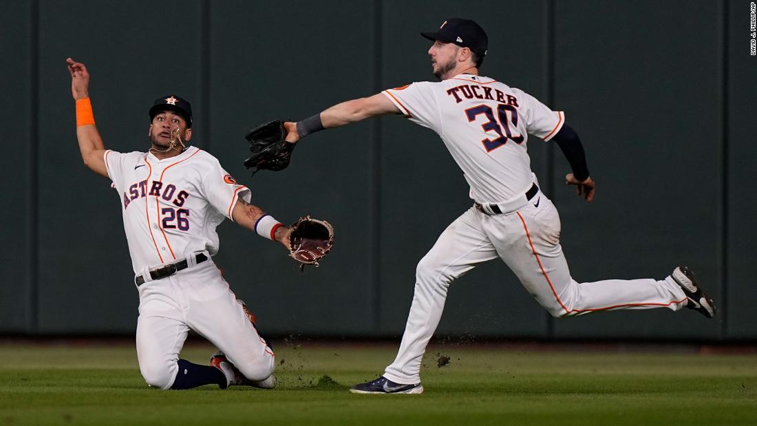 Houston Astros right fielder Kyle Tucker catches a fly ball as center fielder Jose Siri falls during the eighth inning.