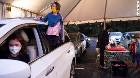 Cate Zeigler-Amon, 10, hangs out of the car as she waits with her mother, Sara Zeigler, to receive her first dose of a Covid-19-19 vaccine at a Viral Solutions vaccination and testing site in Decatur, Georgia, on Wednesday.