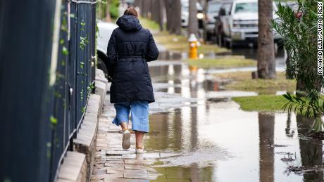 A woman makes her way around floodwaters in the historic Battery Street area on November 5, 2021, in Charleston, South Carolina.
