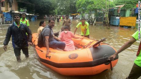 Firefighters rescue people on a boat from a flooded residential area after heavy rain in Chennai on November 7.
