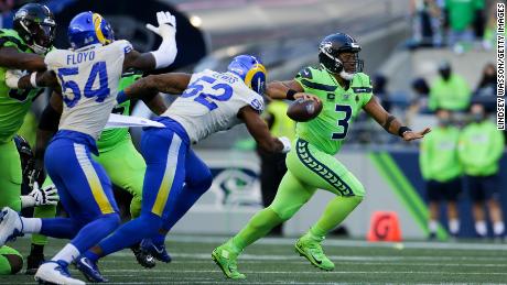 Wilson scrambles against pressure from Rams linebacker Terrell Lewis on October 7 in Seattle.