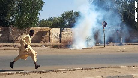 A Sudanese opponent of the military coup runs from tear gas launched by security forces during a protest in city of Umdurman, op November 13.