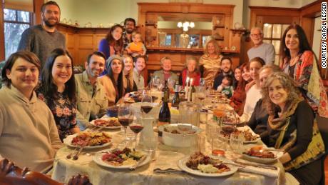 Edward and Susana, seated on the far left, join Carol, standing on the far right, and her family for Thanksgiving dinner.