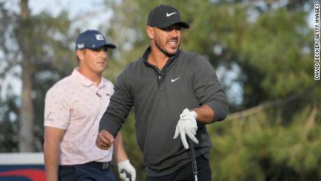 Brooks Koepka plays his shot from the 10th tee as Bryson DeChambeau looks on during Capital One&#39;s &quot;The Match&quot; at Wynn Golf Course on November 26, 2021 in Las Vegas, Nevada.