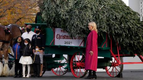 First lady Jill Biden, 권리, and DC Army National Guard Capt. Maryanne V. Harrell and her family pose for a photo with the official 2021 White House Christmas Tree, grown in North Carolina, as it arrives at the White House on Nov. 22, 2021.