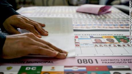 A polling official prepares ballots for voters on November 28, 2021 in Tegucigalpa, Honduras. Honduras holds general elections where the next President will be elected, fears of fraud place the country under a tense situation.